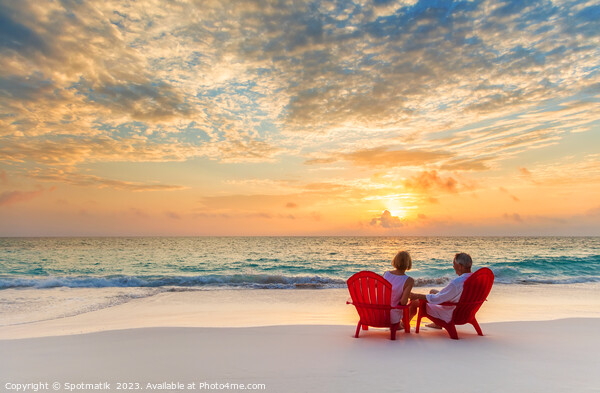 Retired couple enjoying tropical sunrise over ocean Bahamas Picture Board by Spotmatik 