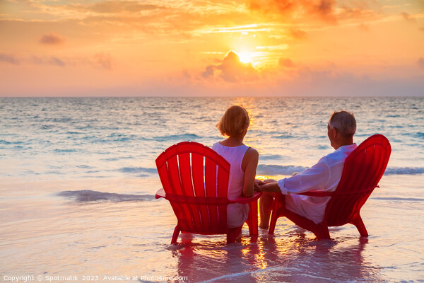 Retired couple enjoying sunset view over ocean Bahamas Picture Board by Spotmatik 