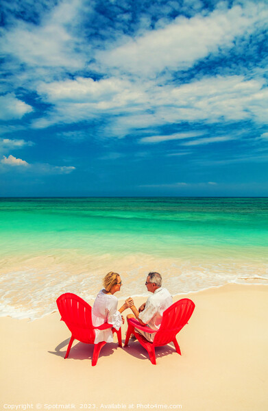 Mature couple on red chairs by ocean Bahamas Picture Board by Spotmatik 