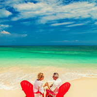 Buy canvas prints of Mature couple on red chairs by ocean Bahamas by Spotmatik 