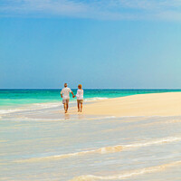 Buy canvas prints of Mature couple walking on beach by ocean Bahamas by Spotmatik 