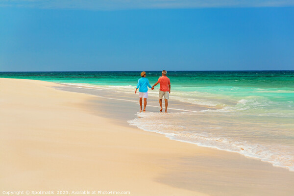 Mature couple paddling on tropical island shoreline Bahamas Picture Board by Spotmatik 