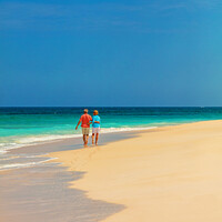 Buy canvas prints of Tropical island shoreline with retired couple walking barefoot by Spotmatik 