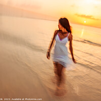 Buy canvas prints of Motion blurred woman walking through waves at sunset by Spotmatik 