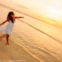Buy canvas prints of Motion blur carefree Asian female dancing on shoreline by Spotmatik 