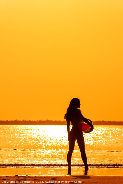 Tropical ocean sunrise with girl holding beach ball Picture Board by Spotmatik 