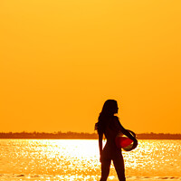 Buy canvas prints of Tropical ocean sunrise with girl holding beach ball by Spotmatik 