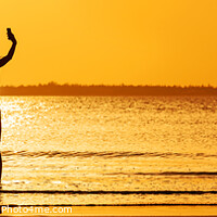 Buy canvas prints of Panoramic ocean sunrise with females silhouette taking selfie by Spotmatik 