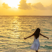 Buy canvas prints of Asian female dancing in ocean waves at sunrise by Spotmatik 