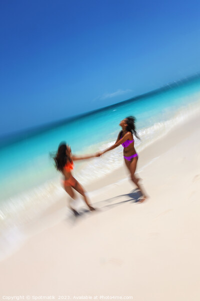 Motion blurred women in swimwear playing by ocean Picture Board by Spotmatik 