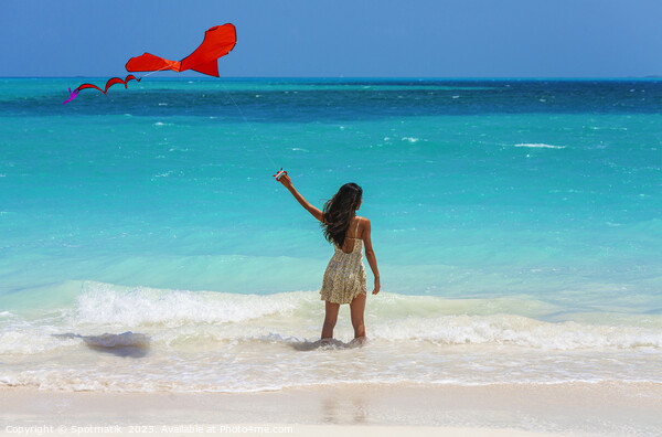 Asian girl standing in ocean waves flying kite Picture Board by Spotmatik 