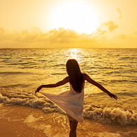 Buy canvas prints of Asian girl standing in ocean waves at sunrise by Spotmatik 