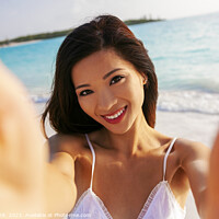 Buy canvas prints of Portrait of beautiful Asian girl smiling by ocean by Spotmatik 