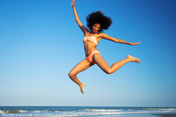 Fun loving Afro female jumping by the ocean Picture Board by Spotmatik 
