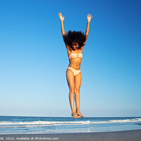 Buy canvas prints of Afro American woman in swimwear jumping for joy by Spotmatik 