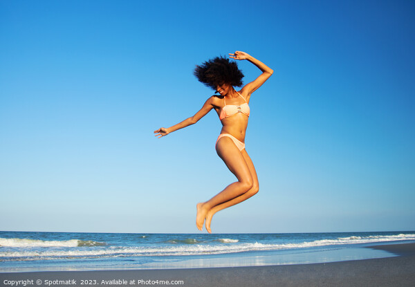 Afro American woman jumping for joy on beach Picture Board by Spotmatik 