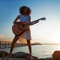Buy canvas prints of Young African American woman playing guitar at sunrise by Spotmatik 
