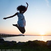 Buy canvas prints of African American woman jumping by ocean at sunset by Spotmatik 