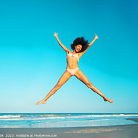 Buy canvas prints of Healthy African American girl jumping high on beach by Spotmatik 