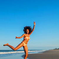 Buy canvas prints of Playful young Afro American woman by the ocean by Spotmatik 