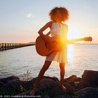 Buy canvas prints of Afro American girl playing guitar with ocean sunset by Spotmatik 