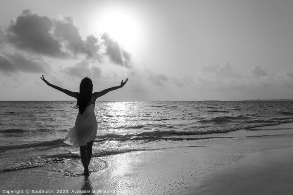 Asian woman by the ocean with outstretched arms Picture Board by Spotmatik 