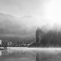 Buy canvas prints of Family playing on shores of Derwent Water on a cold winters morning with mist and sun beams by Julian Carnell