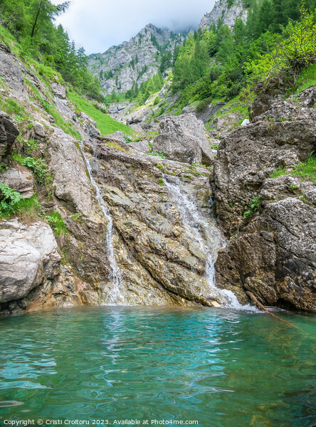 Small waterfall with the water flowing through the rock in a natural pool with turquoise color Picture Board by Cristi Croitoru