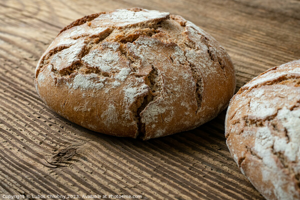 Delicious baked bread on a wooden background Picture Board by Lubos Chlubny