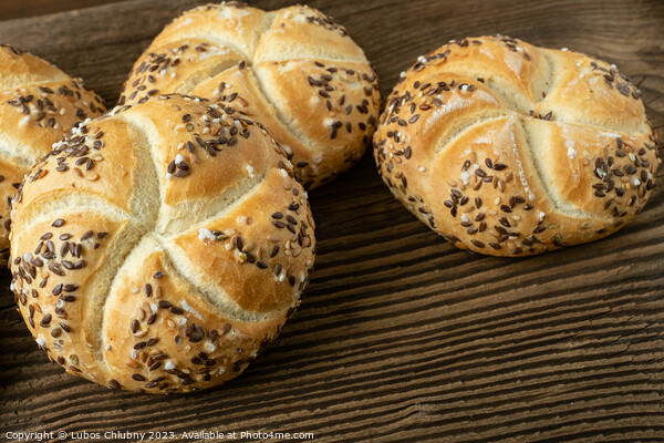 Whole wheat bread on wooden background. Bunch of kaiser rolls with sesame. Picture Board by Lubos Chlubny