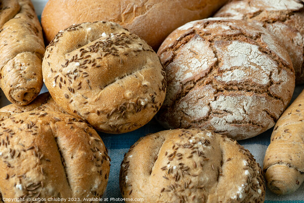 Heap of various bread rolls sprinkled with salt, caraway and sesame. Fresh rustic bread from leavened dough. Assortment of freshly of bakery products Picture Board by Lubos Chlubny