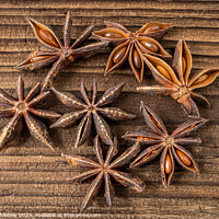 Buy canvas prints of Dried star anise spice on vintage wooden board by Lubos Chlubny