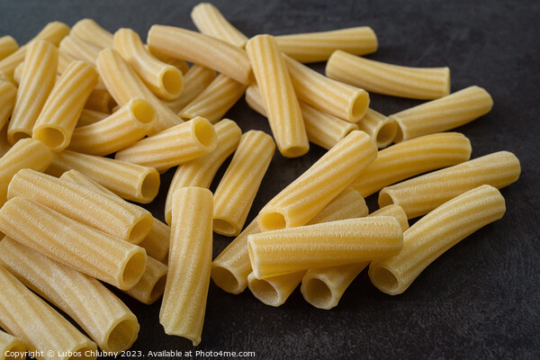 Raw italian penne rigate pasta isolated on black background Picture Board by Lubos Chlubny