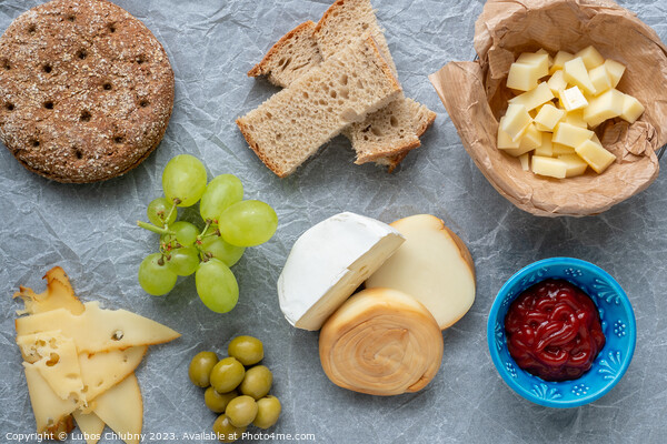 Cold appetizer. Cold cuts. Different snacks on a white crumpled paper, from above. Picture Board by Lubos Chlubny