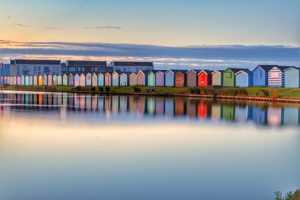 Sunrise reflections along the beach huts  Picture Board by Tony lopez