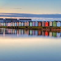 Buy canvas prints of Sunrise reflections along the beach huts  by Tony lopez