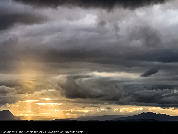 Sunlight Breaking Through a Stormy Scottish Sky Picture Board by Ian Donaldson
