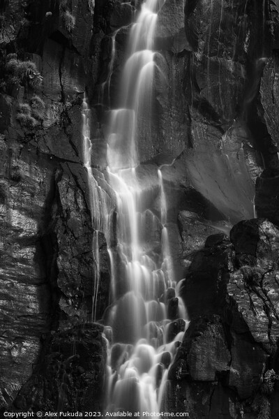 A waterfall cascading down black rock cliff Picture Board by Alex Fukuda