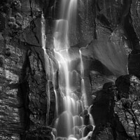 Buy canvas prints of A waterfall cascading down black rock cliff by Alex Fukuda