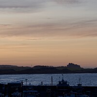 Buy canvas prints of Sunset at Seahouses harbour bamburgh castle in the distance by Helen Reid