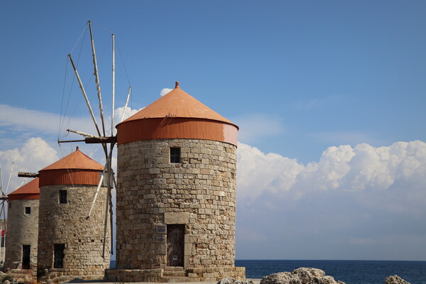 Windmills at the seafront in the city of Rhodes in Rhodes island in Greece Picture Board by Virginija Vaidakaviciene