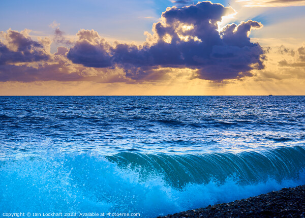 Sunset from Brighton beach with light glistening on rolling waves Picture Board by Iain Lockhart