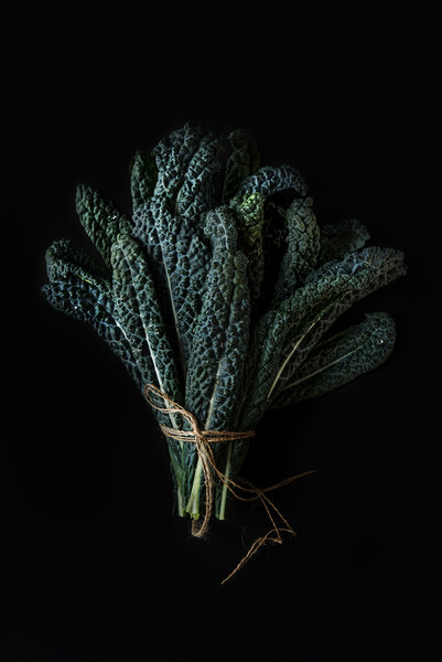 Bouquet of green Kale leaves on a dark background. Picture Board by Olga Peddi