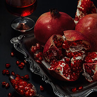 Buy canvas prints of Still life of pomegranates on a black background by Olga Peddi