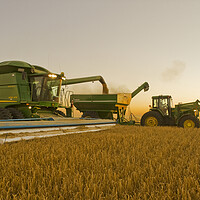Buy canvas prints of a combine unloads barley in to a grain wagon on the go by Dave Reede