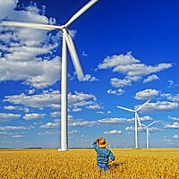 Buy canvas prints of man in spring wheat field viewing wind turbines by Dave Reede