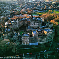 Buy canvas prints of Aerial view of a historic Lancaster castle amidst a lush urban landscape at sunset. by Man And Life