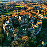 Buy canvas prints of Aerial view of a majestic Lancaster castle surrounded by greenery with a town in the background during sunset. by Man And Life
