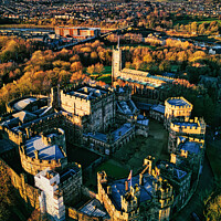 Buy canvas prints of Aerial view of a historic Lancaster castle at sunset with surrounding gardens and distant cityscape. by Man And Life