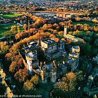 Buy canvas prints of Aerial view of a historic Lancaster castle amidst a lush green landscape with surrounding urban area during golden hour. by Man And Life